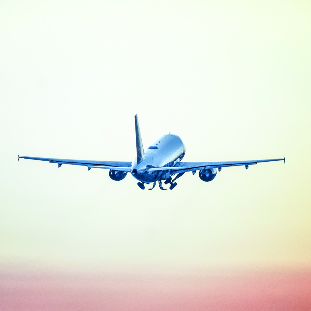 Low angle view of airplane flying against sky during sunset